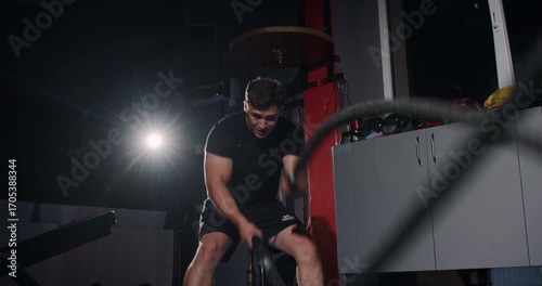 In a dim boxing ring, a determined man showcases his skills in an intense match