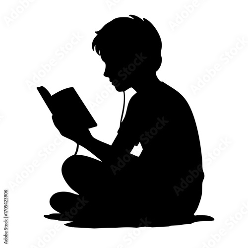 Silhouette of young boy sitting and reading a book with earbuds  