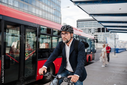 Φωτογραφία City commuter riding bike to office, wearing backpack and helmet.