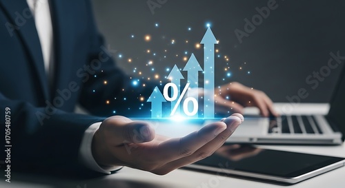 Businessman holding glowing percentage sign and upward arrow graph with digital elements