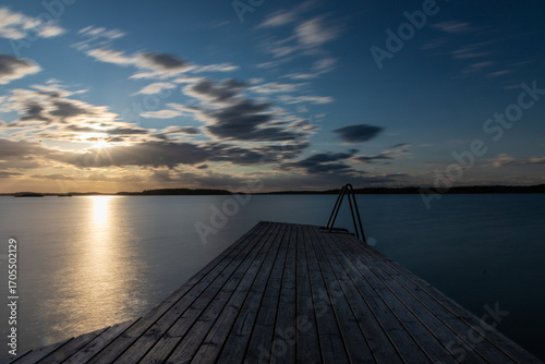 Amazing golden sunset over the Turku archipelago in south east Finland with a view on a typical swimming jetty which are everywhere on the many islands for locals to enjoy the Balic sea after a sauna