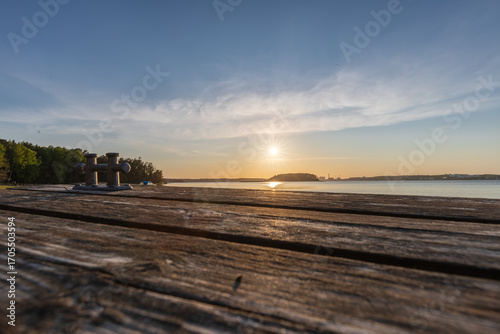 Fototapeta Naklejka Na Ścianę i Meble -  Amazing golden sunset from Ruissalo island over the Turku archipelago in south west Finland with a view on a swimming jetty which are everywhere on the many islands for locals to enjoy the Baltic sea 
