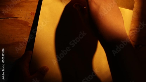 Close-up of someone opening the document that contains a security document that has been marked FAKE with a red stamp.