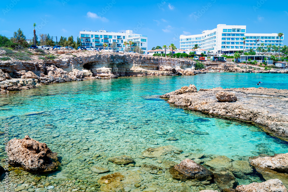 Fototapeta premium Bay with turquoise water on Cypriot beach in popular holiday resort, Nisia Loumbardi, Paralimni, Cape Greco, Cyprus. The most beautiful places Cyprus. 