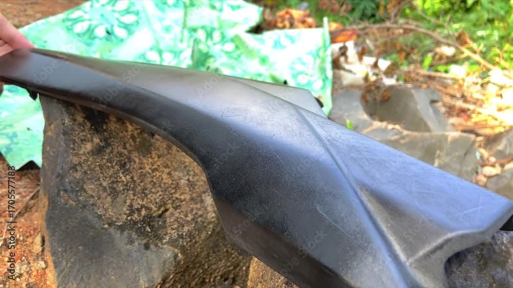 Close Up of Spray Painting Motorcycle Part Outdoors