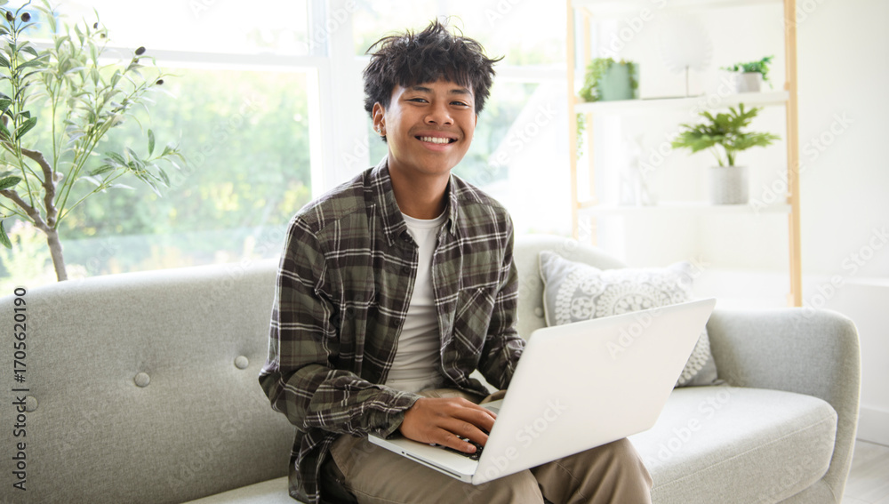 Fototapeta premium thai teen using laptop at home sofa
