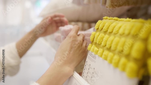 Close up of hands browsing textile display in store, exploring soft fabrics, textures and colors, highlighting comfort, quality, style, and lifestyle choice in shopping experience
