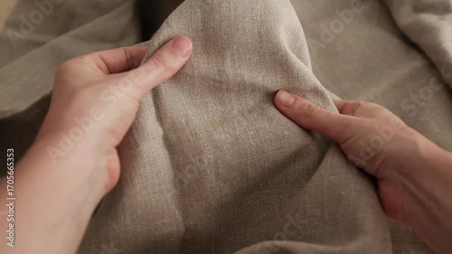 Closeup video of hands touching rough linen fabric. Appreciating texture of natural textile for clothes. Natural organic textile.