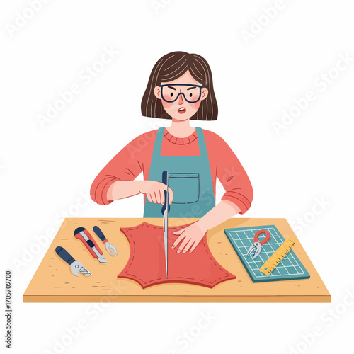 Focused young woman meticulously cutting a piece of red leather with a craft knife for a handmade project
