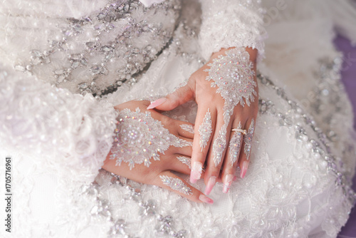 Elegant Brides Hands Adorned with Lace and Ring on White Wedding Dress.