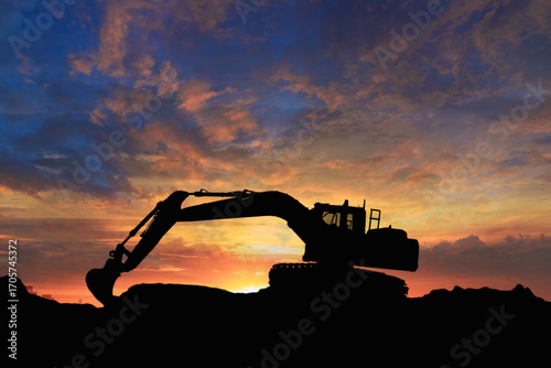 Crawler excavators silhouette are digging the soil in the construction site. With blue sky and clouds of on sunset background