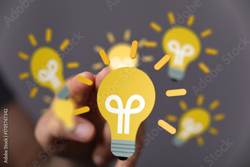 Person chooses a lightbulb, symbolizing innovation, ideas, and solutions.