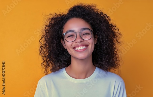 Young Woman With Curly Hair Smiles Against a Bright Yellow Background During ...