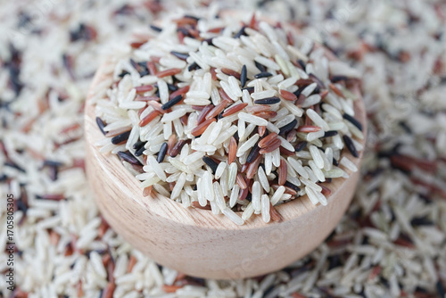 Close up of brown rice on a wooden bowl on background. Healthy food.