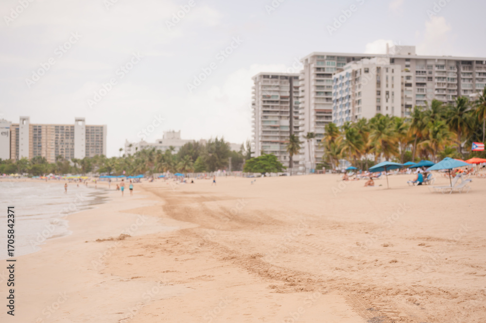 Obraz premium People relaxing on Isla Verde Beach near tall buildings, Puerto Rico with copy space