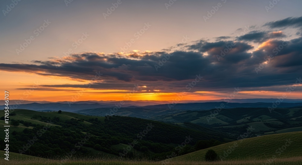 Obraz premium Mountain range silhouette at sunset, vibrant golden sky with clouds