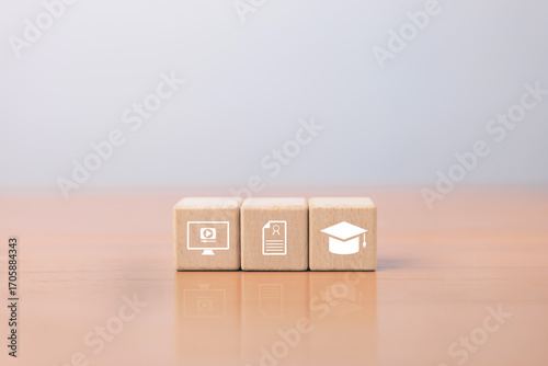 Wooden blocks with online learning icons, certificate and graduation cap symbolizing online learning, digital education.