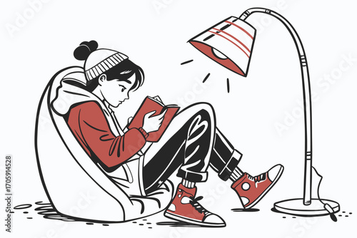 Asian teen girl reads a book while sitting under a lamp with red accents