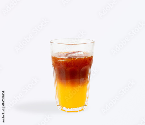 Refreshing iced americano coffee layered with bright orange juice, served in a tall clear glass with ice cubes and condensation for a summer vibe