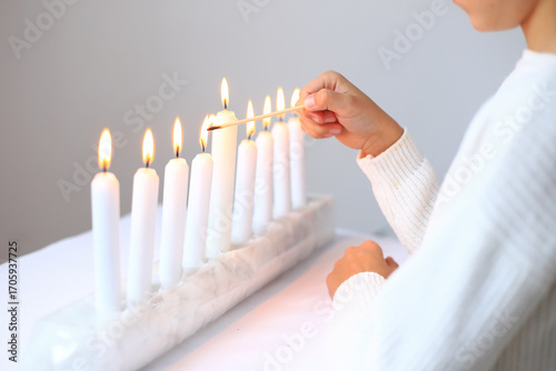 the ritual of lighting candles on the menorah during Hanukkah. The flames flicker gently, casting a warm glow that symbolizes hope and miracles. This cherished tradition brings families together