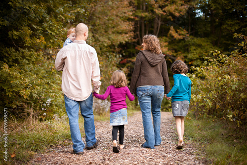 Young Family on Nature Walk Together on Path in Forest