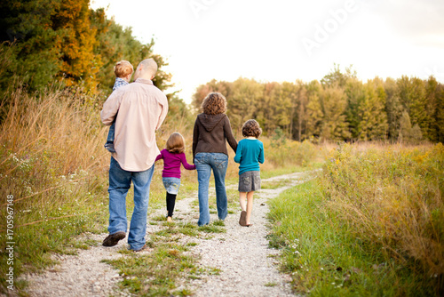 Young Family Walking Away Down a Path Together in Nature
