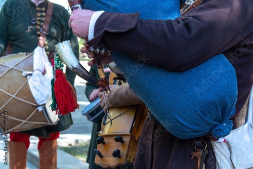 A historical reenactment festival featuring musicians playing traditional instruments like drums and horn pipes in outdoor setting