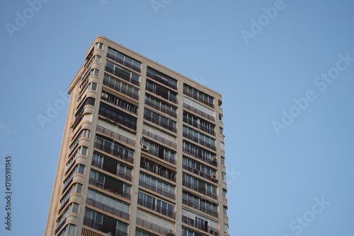 Benidorm, Spain – September 7 2025: Stunning high rise apartment building in Benidorm against a clear blue sky.