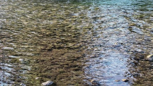 Panoramic video of a river with clear, transparent water and a rocky bottom.  Camera movement from right to left.