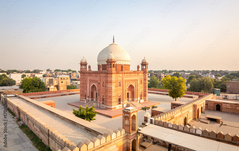 Obraz premium An ancient mughalera tomb with a dome and minarets, set within a walled complex, bathed in the warm light of sunset