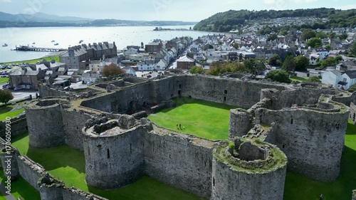 Aerial view of  the medieval ruins of Beaumaris Castle and the coastal town of Beaumaris on the Isle of Anglesey in Gwynedd off the north Wales coast. The castle dates from around 1295.