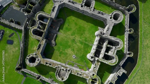Aerial view of  the medieval ruins of Beaumaris Castle and the coastal town of Beaumaris on the Isle of Anglesey in Gwynedd off the north Wales coast. The castle dates from around 1295.