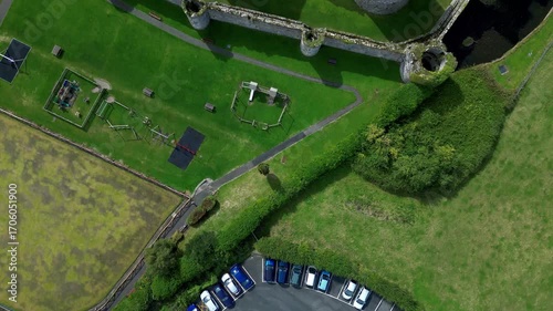 Aerial view of  the medieval ruins of Beaumaris Castle and the coastal town of Beaumaris on the Isle of Anglesey in Gwynedd off the north Wales coast. The castle dates from around 1295.