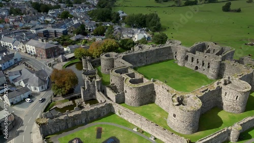 Aerial view of  the medieval ruins of Beaumaris Castle and the coastal town of Beaumaris on the Isle of Anglesey in Gwynedd off the north Wales coast. The castle dates from around 1295.