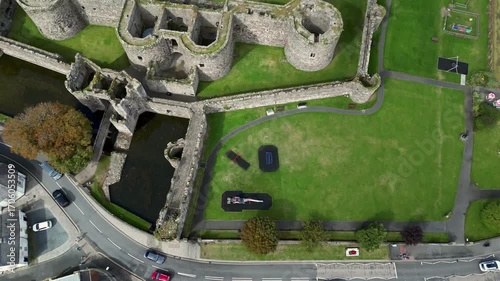 Aerial view of  the medieval ruins of Beaumaris Castle and the coastal town of Beaumaris on the Isle of Anglesey in Gwynedd off the north Wales coast. The castle dates from around 1295.