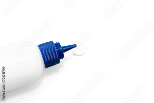 White glue bottle with blue cap dispensing a drop on textured surface close up  on a transparent Background