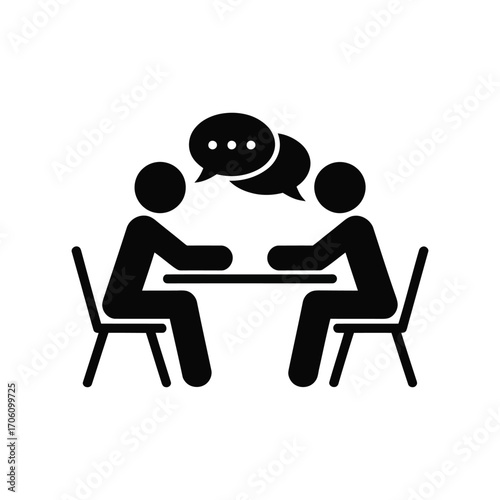 Black and white icon of two people seated at a table with overlapping speech bubbles, symbolizing dialogue, meeting, and interpersonal exchange