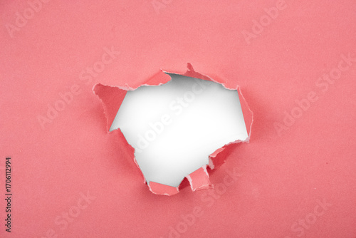 Torn pink paper texture revealing a dark void for abstract creative concepts