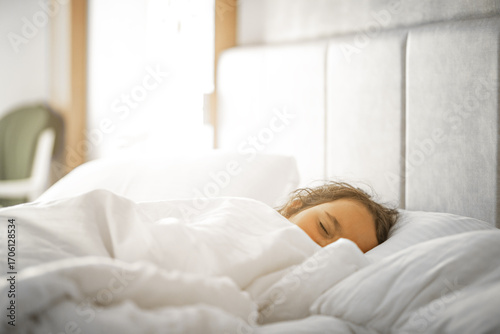 Cute little kid girl sleeping on bed.