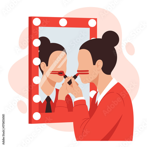 Woman applying makeup in front of a lighted mirror.