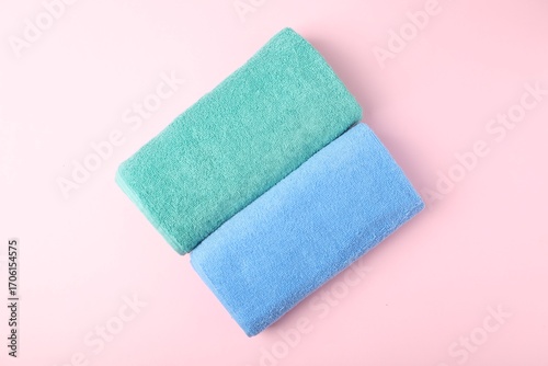 Bright terry towels on pink background, top view