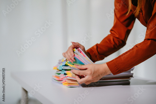 Young beautiful asian businesswoman holding unofficial spreadsheet paper accounting documents Division of documents to prepare the search Summarize the plan in a meeting at the office.