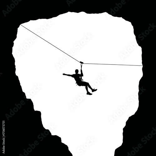 Silhouette of a person ziplining across a vast white cavernous opening against a black background