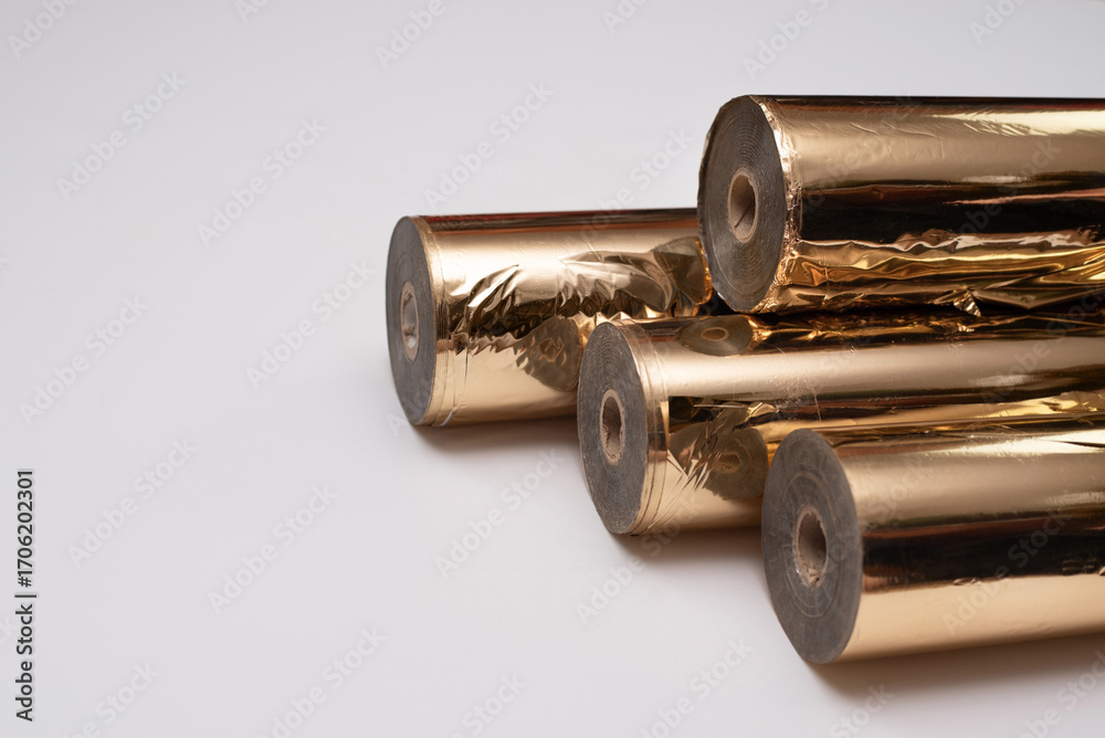 Naklejka premium Metallic gold foil in rolls used in printing to transfer logo text through embossing onto finished printed products as decoration, space for text