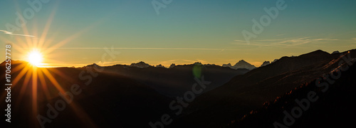composizione panoramica che mostra un paesaggio naturale tra le montagne Italiane in Friuli Venezia Giulia, con cielo sereno, al tramonto, in autunno