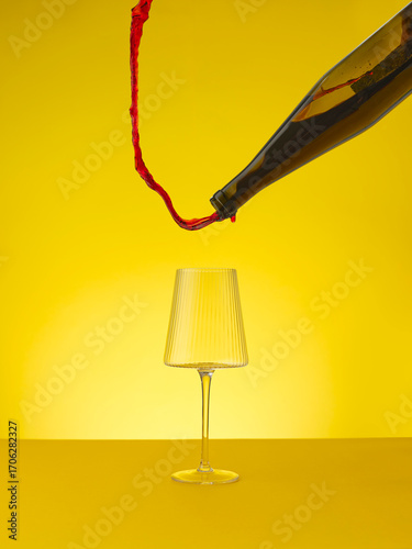 Red wine pouring upwards away from wine glass 