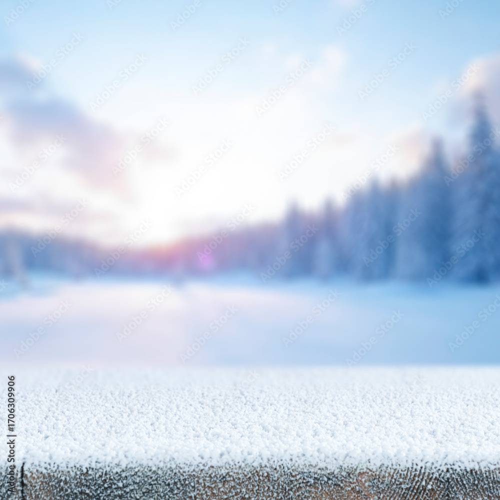 Obraz premium Snowy mountain landscape in the heart of winter, with tree-covered slopes and frosty pine forests under a bright winter sky. Empty wooden surface snow-covered space perfect for product placement.