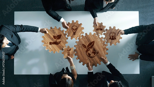 Quadro su tela A professional team engages in a collaborative business meeting focused on sustainability, represented by wooden gears with eco-friendly symbols, fostering innovative solutions