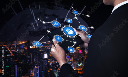 Photography A business professional stands against a sprawling urban skyline at night, engaging with virtual network connections, symbolizing modern communication and technology