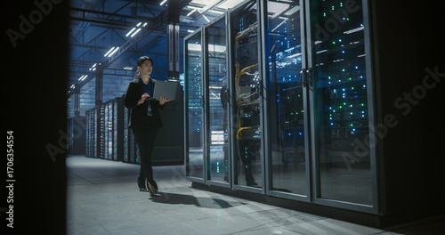 Wide view of technician walking in data center.